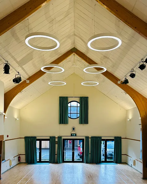 Community centre brightly lit by feature pendants